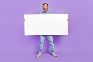 Full body photo of aged man hold big paper white banner promotion isolated over violet color background