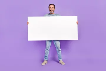  Full body photo of aged man hold big paper white banner promotion isolated over violet color background © deagreez