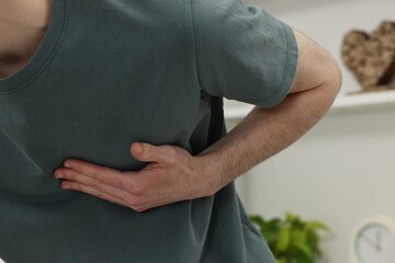 Man suffering from heart hurt at home, closeup