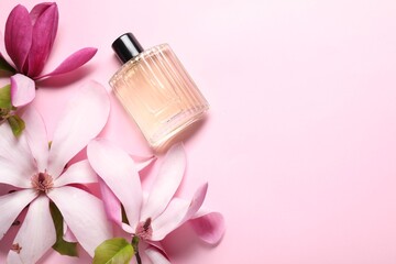 Obraz na płótnie Canvas Beautiful magnolia flowers and bottle of perfume on pink background, flat lay. Space for text