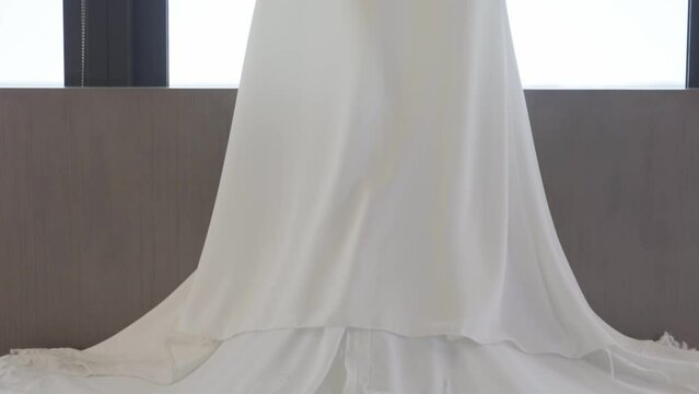 Wedding dress hangs over bed