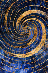 Geometric pattern design of swirling vortex of intersecting lines and shapes forms a hypnotic pattern, gold and blue