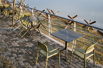 Empty tables and plastic chairs on the summer terrace near a small cafe. Cafeteria furniture outside