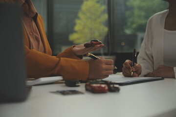 Insurance officers hand over the car keys after the tenant. have signed an auto insurance document...