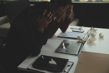 Stressed annoyed office employee manager having headache migraine at business meeting with his colleagues about business problem they have to solve. Stress at work or migraine concept.