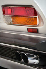 The tail light and exhaust pipe of a vintage car.
