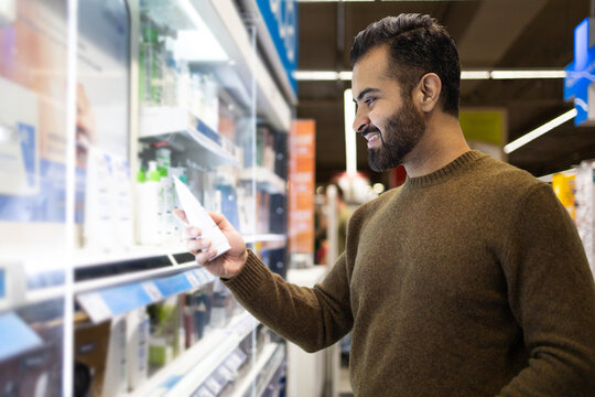 Smiling man choosing products in a supermarket aisle