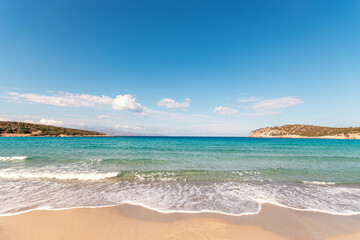 Fototapeta premium Soft waves of the sea on the beautiful beach on sky background. Voulisma beach in Creta island.