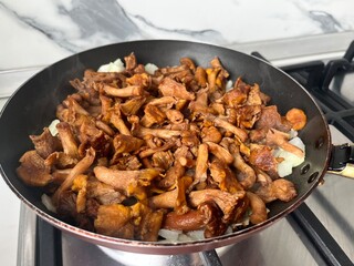 Fried chanterelles with onions in a frying pan