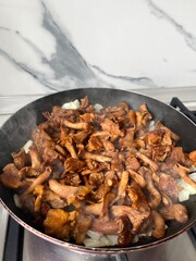 Fried chanterelles with onions in a frying pan