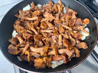 Fried chanterelles with onions in a frying pan