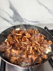 Fried chanterelles with onions in a frying pan