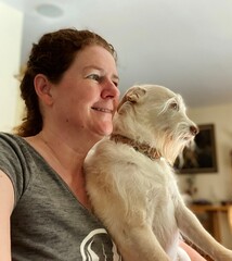 portrait of Smiling woman with dog on lap at home