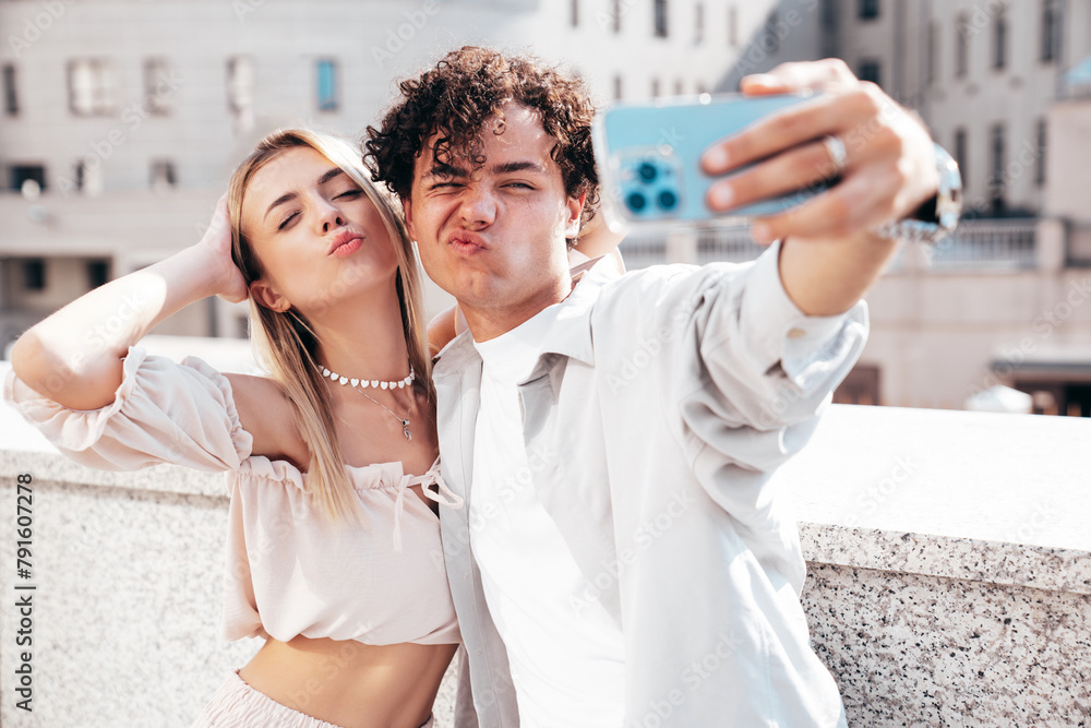 Canvas Prints Young smiling beautiful woman and her handsome boyfriend in casual summer clothes. Happy cheerful family. Female having fun. Couple posing in the street background at sunny day. Take selfie