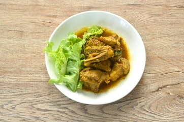 spicy fried pork bone with curry with fresh green oak salad on plate