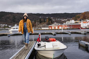 Young Woman Walking on Dock by Moored Boat in Norwegian Harbor