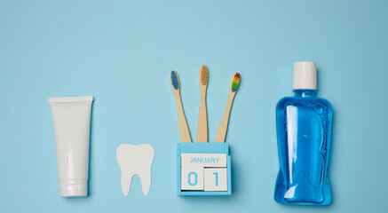 Mouthwash, toothpaste tube, dental floss on a blue background, oral hygiene.