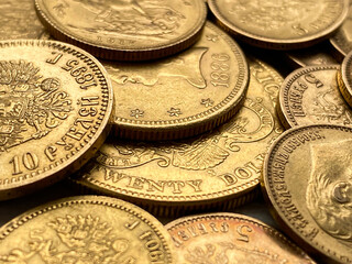 Zbliżenie, detal prawdziwych złotych monet, amerykańskie 20 dolarów, 10 dolarów, suweren brytyjski, 10 rubli Mikołaj II Romanow. Złote monety 1897-1911.