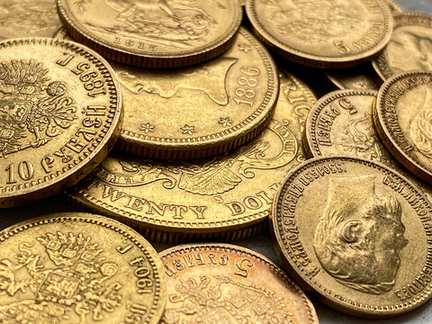 Zbliżenie, detal prawdziwych złotych monet, amerykańskie 20 dolar&oacute;w, 10 dolar&oacute;w, suweren brytyjski, 10 rubli Mikołaj II Romanow. Złote monety 1897-1911.