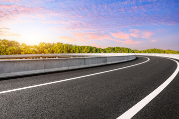 Asphalt road and green trees with sky clouds background