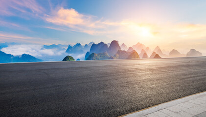 Asphalt highway road and karst mountain with sky clouds at sunrise