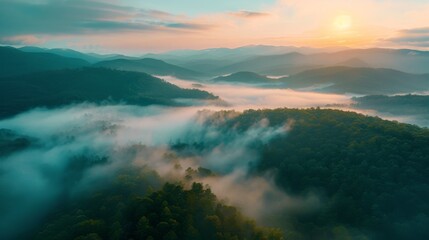 An aerial view of misty mountains at dusk with water, clouds, and dramatic sky - obrazy, fototapety, plakaty