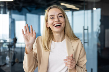 Professional woman greeting on a video call in modern office