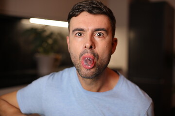 Man holding an ice cube between his lips   - Powered by Adobe