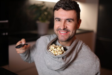 Hilarious man using the hood of the hoodie to store his popcorn while watching tv