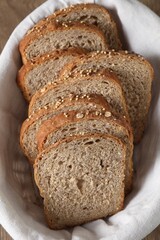 Slices of fresh bread in basket on table, above view