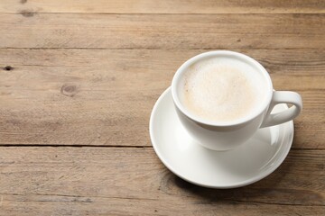 Cup of aromatic coffee on wooden table. Space for text