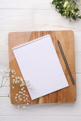 Guest list. Notebook, pencil, beautiful flowers and ribbon on white wooden background, flat lay