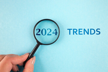 The image features magnifier glasses with the text New Year 2024 Trends, emphasizing the main trend of change. It represents the evaluation methods