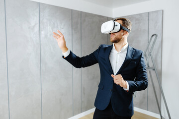 Young man wearing VR glasses, scrolling with hands in air using futuristic innovative technology...