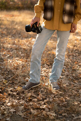 Nature Photography Concept. Professional photographer with dslr camera in autumn forest - obrazy, fototapety, plakaty