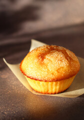 Dessert small cupcake on parchment on dark background