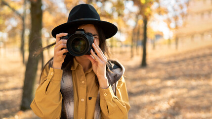 Photographer woman taking a photo outdoor traveling in autumn forest