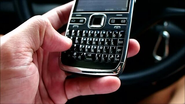 Hand of man using a qwerty keypad phone