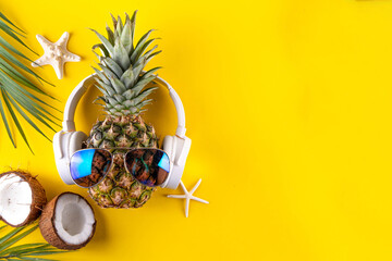 Creative summer vacation, party and holiday background with pineapple in sunglasses and headphones,...