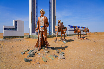 Sculpture of a camel train caravan along the ancient silk road at the gateway to the Khorezm Region of Uzbekistan, located along the A380 highway in the Kyzylkum Desert in Central Asia