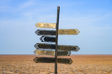Multiple destinations orientation signpost located on an overlook above the ancient shore of the Aral Sea in Moynaq, Karakalpakstan, Uzbekistan