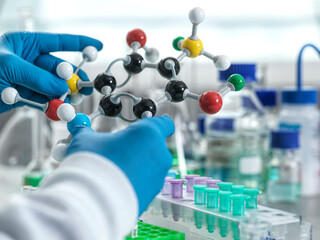 Scientist holding a molecular model in a laboratory setting.