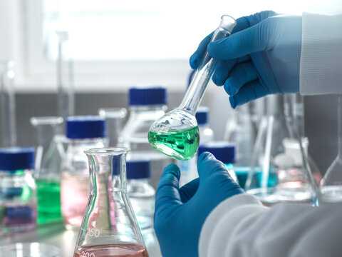 Scientist pouring liquid into flask in laboratory