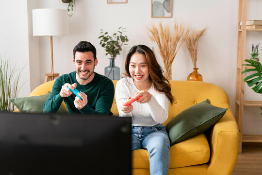 Two people playing video games on a couch.