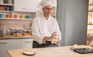 Professional chef kneads dough with expertise. Art of bread-making in a bustling commercial kitchen