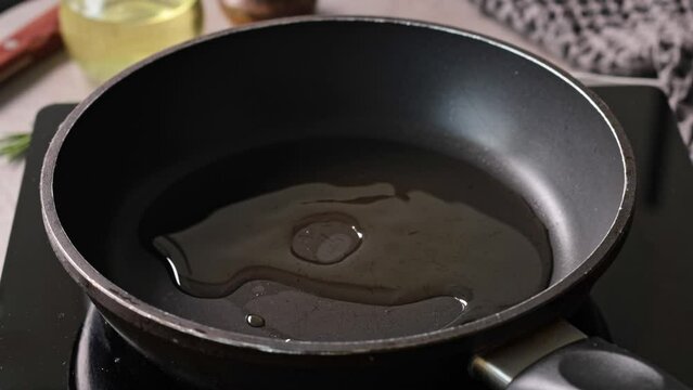 Cook pours oil on hot pan, close-up