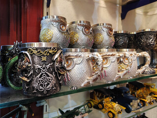 Vintage metal mugs with a decorative image of an owl on a shop window