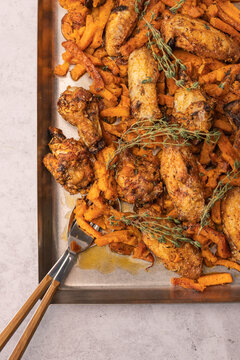 Roasted chicken wings with sweet potatoes top view