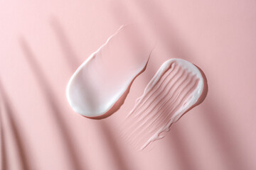 Cosmetic cream textures on a soft pink background