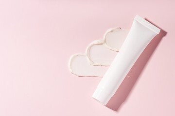 Skincare cream texture with tube on pink background